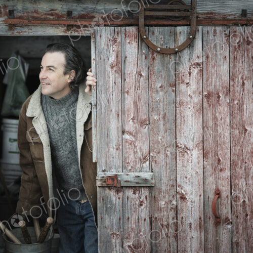 An organic farm in upstate New York, in winter. A man at an open barn door.