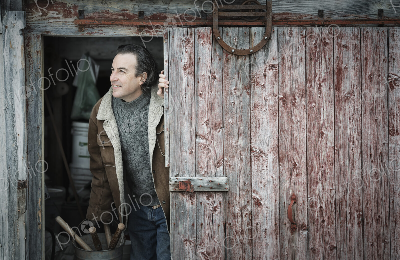 An organic farm in upstate New York, in winter. A man at an open barn door.