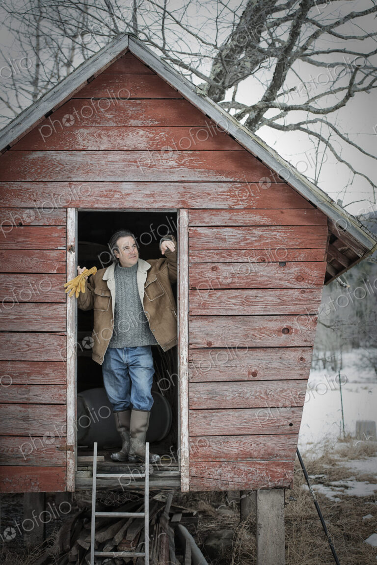 An organic farm in upstate New York, in winter. A man standing in the doorway of a…