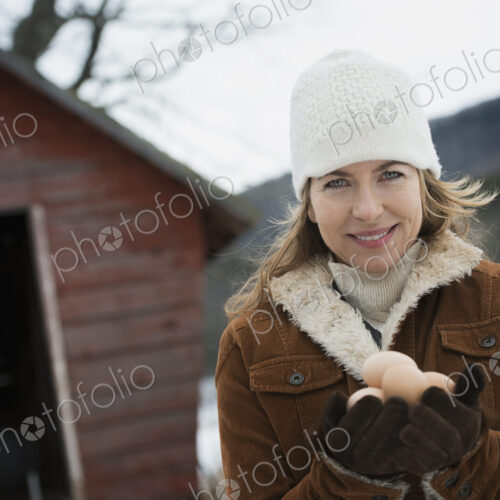 An organic farm in upstate New York, in winter. A woman holding a clutch of hen's eggs… An organic farm in upstate New York, in winter. A woman holding a clutch of hen's eggs…