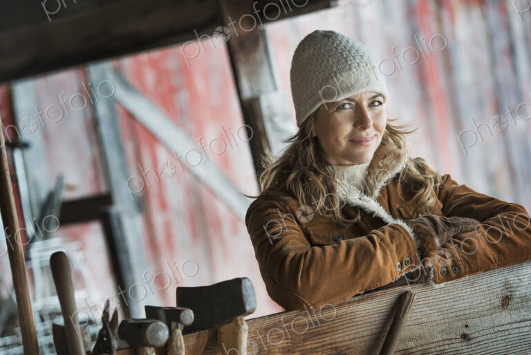 An organic farm in upstate New York, in winter. A woman in a sheepskin coat. A row of…