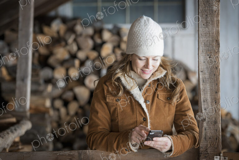 An organic farm in upstate New York, in winter. A woman in sheepskin coat and woollen…