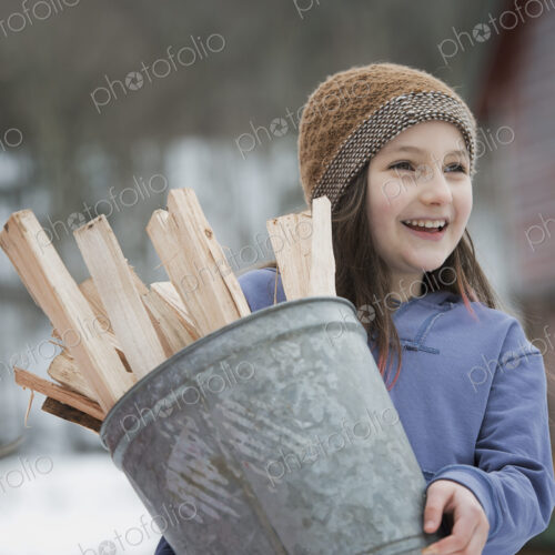 An organic farm in winter in New York State, USA. A girl carrying a bucket full of… An organic farm in winter in New York State, USA. A girl carrying a bucket full of…