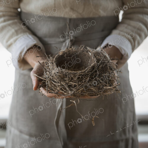 An organic farm in winter in New York State, USA. A woman in a work apron holding a… An organic farm in winter in New York State, USA. A woman in a work apron holding a…
