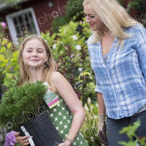 An organic flower plant nursery. A woman and a girl walking. An organic flower plant nursery. A woman and a girl walking.