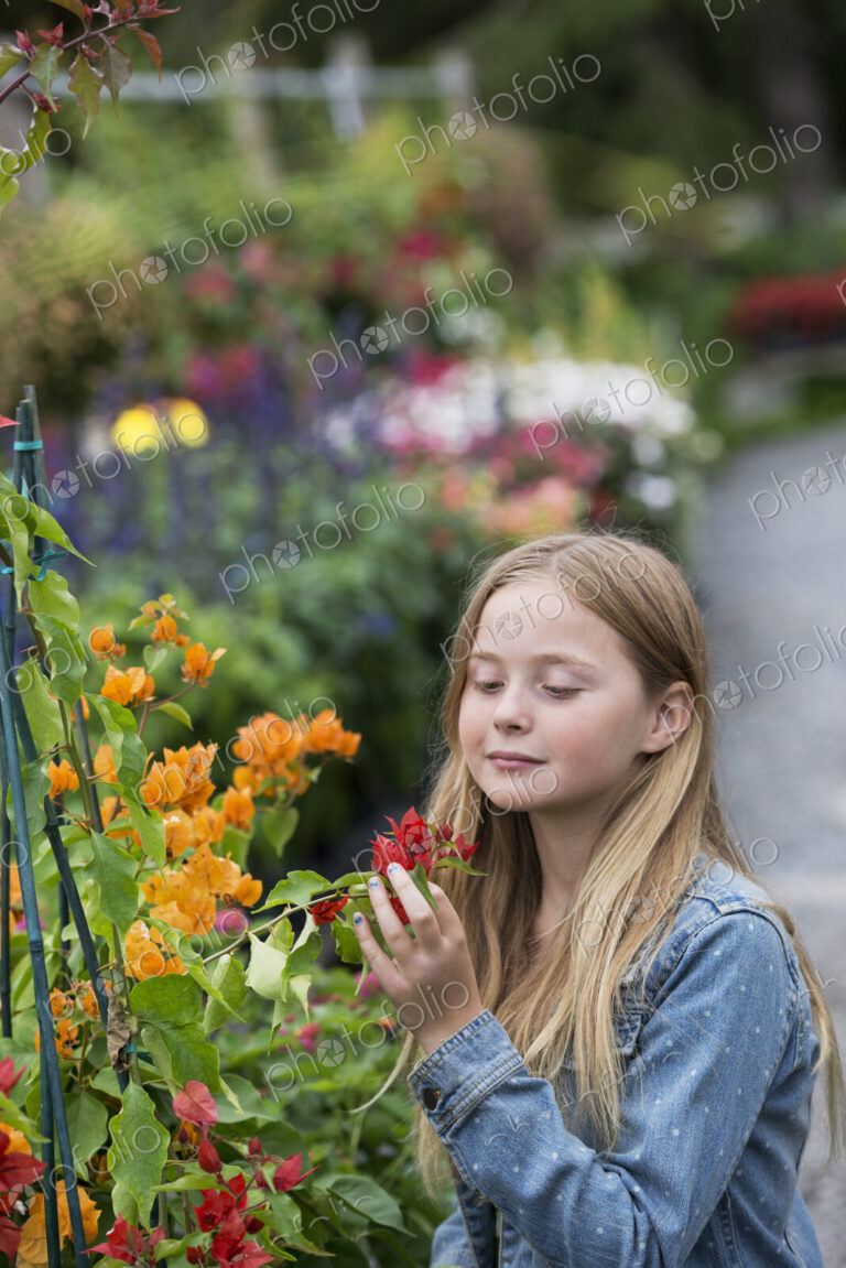 An organic flower plant nursery. A young girl looking at the flowers.