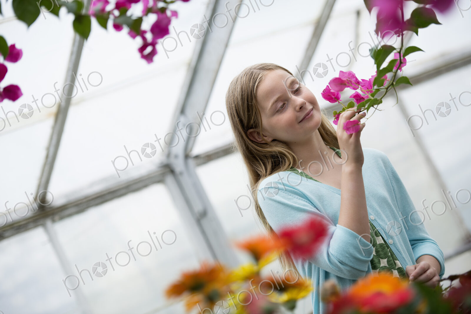 An organic flower plant nursery. A young girl looking at the flowers.