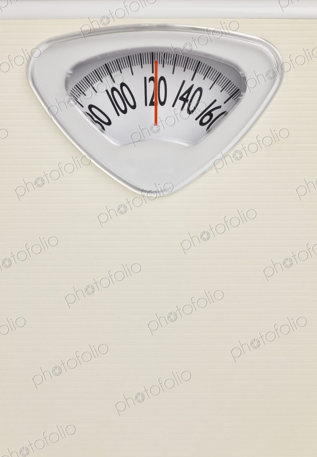Analog bathroom scale close-up with red needle pointing at 120 pounds. Health and…