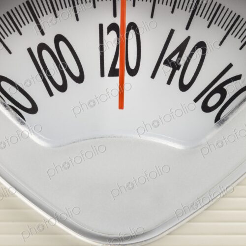 Analog bathroom scale showing 120 pounds. Health, fitness, or weight management…