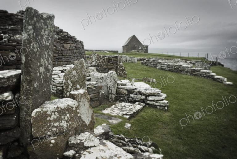Ancient houses and stones in the Broch of Gurness, an Iron Age settlement on Orkney.