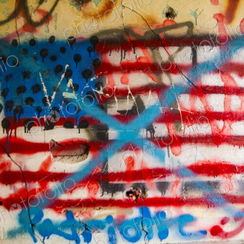 Anti-american grafitti on a wall, the US flag with blue crosses painted over it. Anti-american grafitti on a wall, the US flag with blue crosses painted over it.
