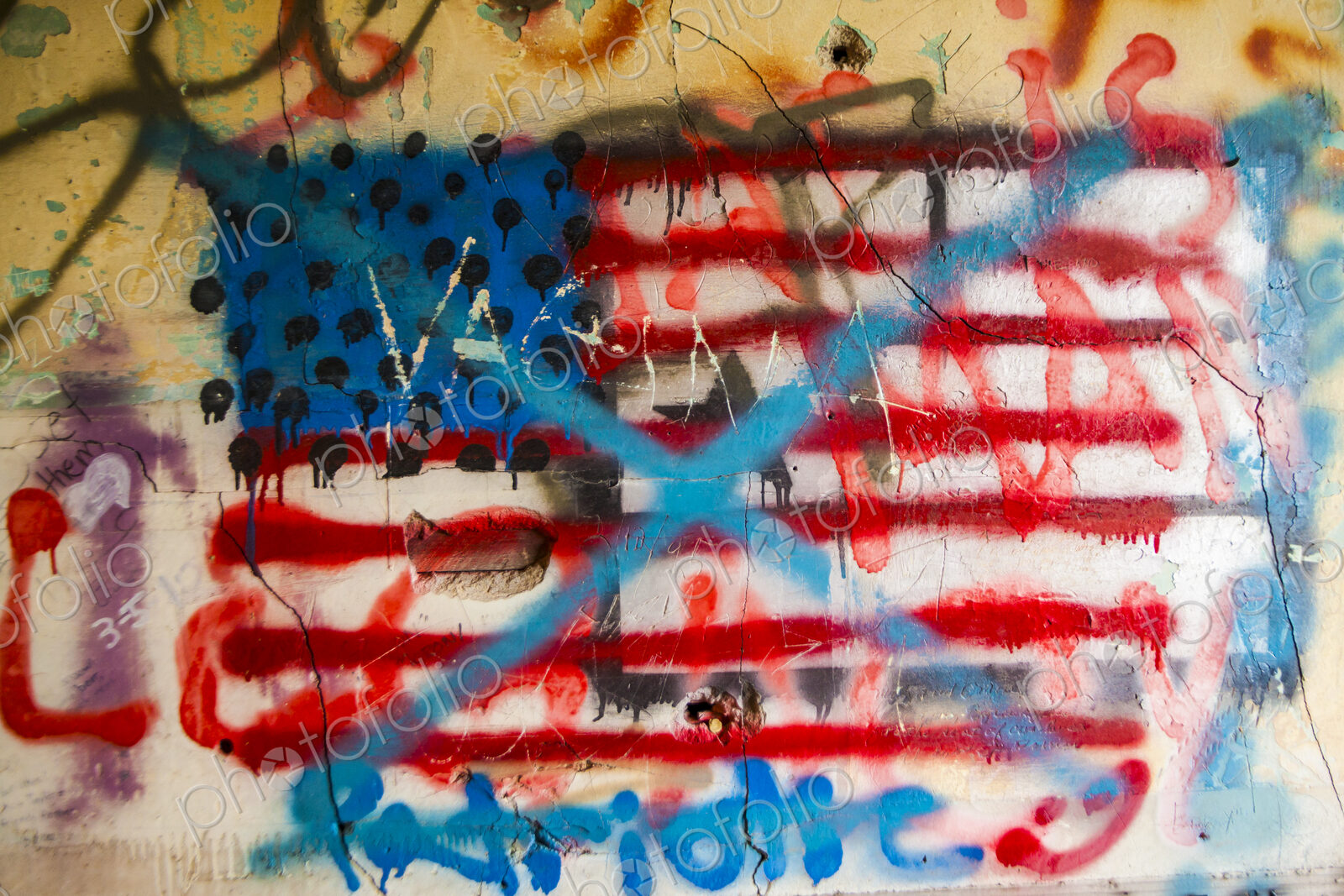 Anti-american grafitti on a wall, the US flag with blue crosses painted over it.