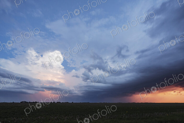 Approaching storm clouds with lightning in Nebraska, a blue sky background, glow on…