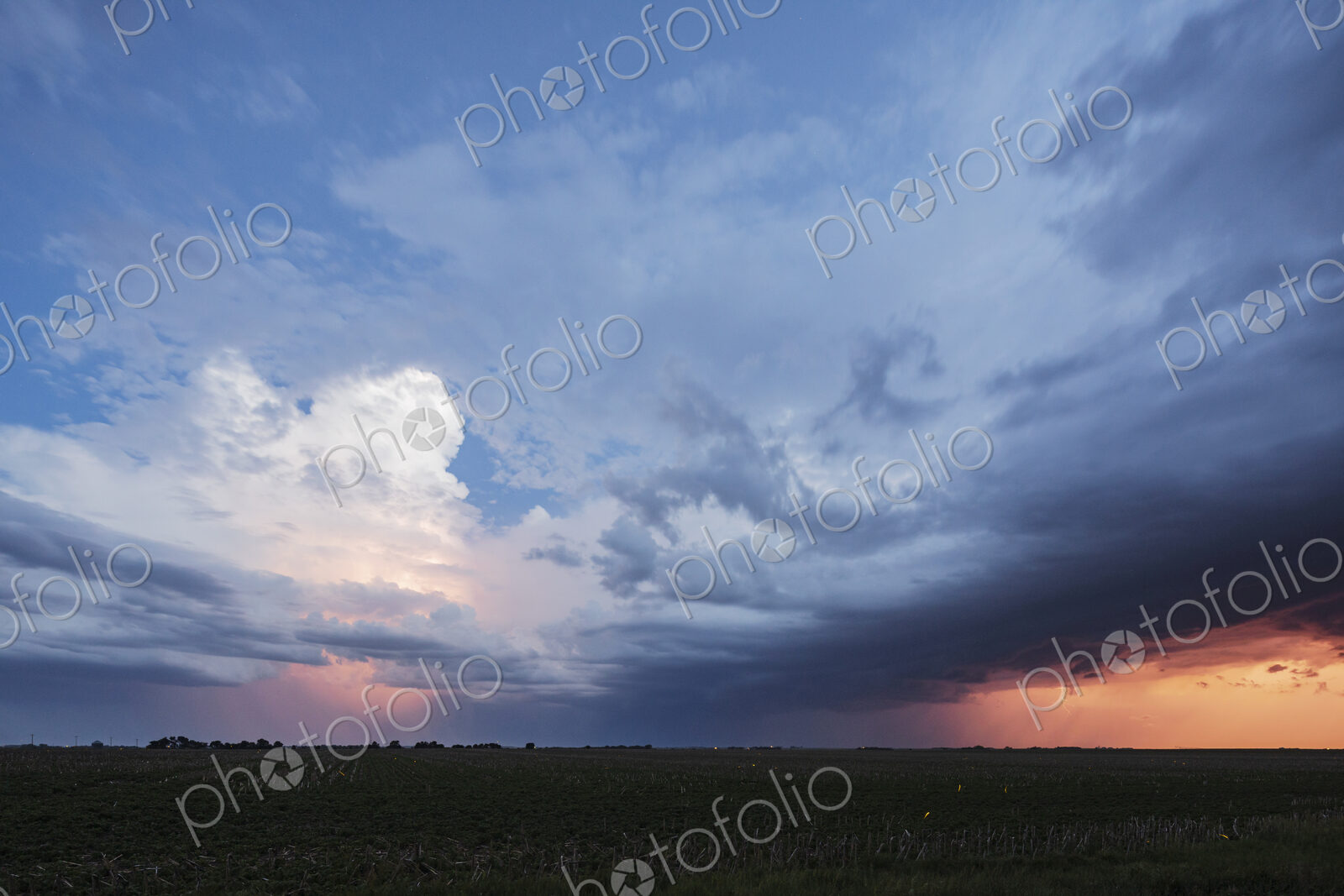 Approaching storm clouds with lightning in Nebraska, a blue sky background, glow on…