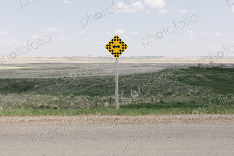 Arrow intersection sign and rural farmland,
