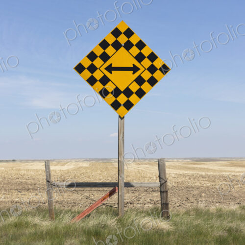 Arrow intersection sign and rural farmland Arrow intersection sign and rural farmland