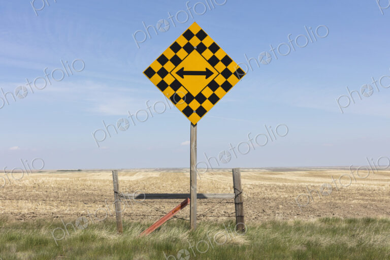 Arrow intersection sign and rural farmland