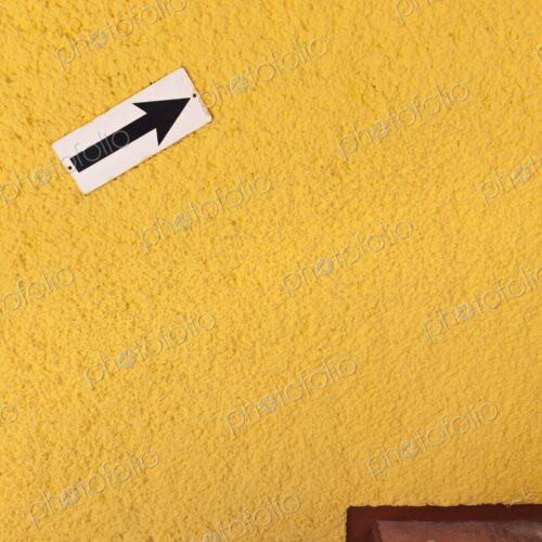 Arrow pointing up on bright yellow wall, Cancun, Yucatan Peninsula, Quintana Roo Arrow pointing up on bright yellow wall, Cancun, Yucatan Peninsula, Quintana Roo
