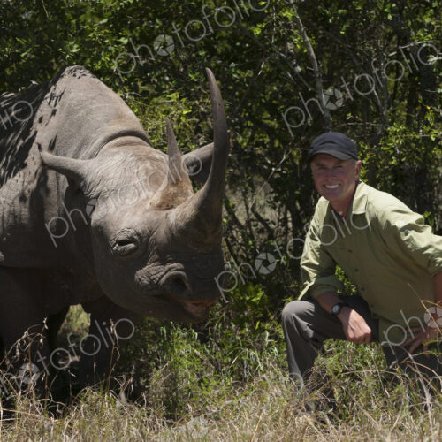Art Wolfe, photographer kneeling next to a white rhinoceros in Kenya. Art Wolfe, photographer kneeling next to a white rhinoceros in Kenya.