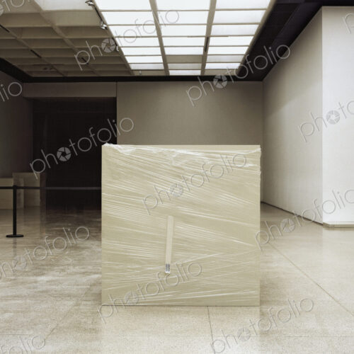 Art gallery space, ceiling light panels, marble floor tiles and exhibition plinth.