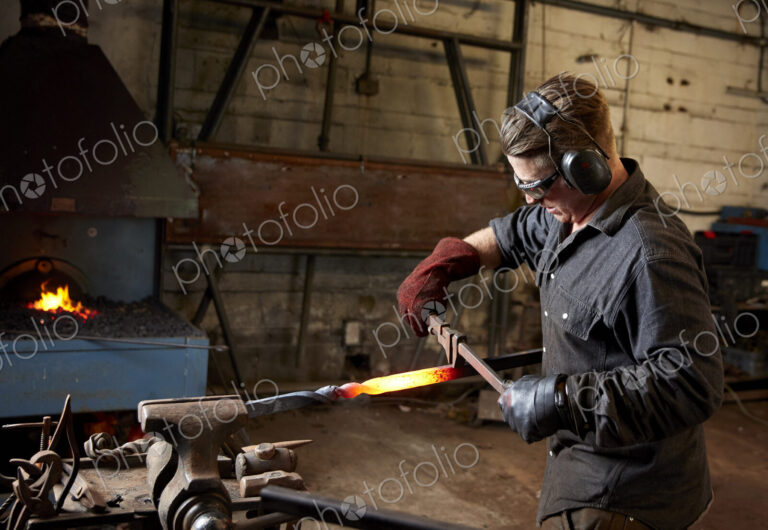 Artisan metal worker shaping a red hot piece of metal