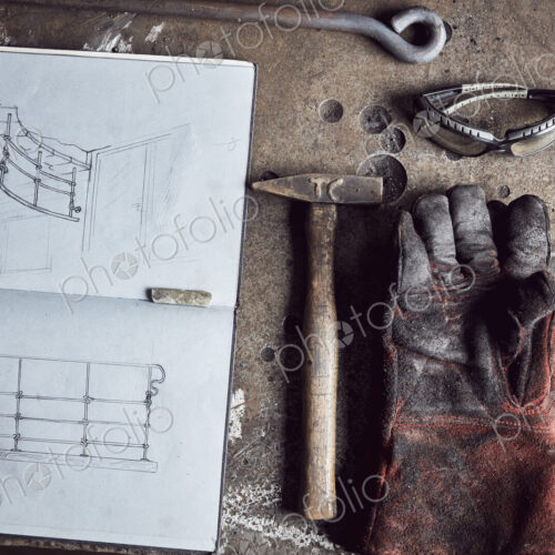 Artisan metalworker's tools, sketches in a notebook and a glove Artisan metalworker's tools, sketches in a notebook and a glove