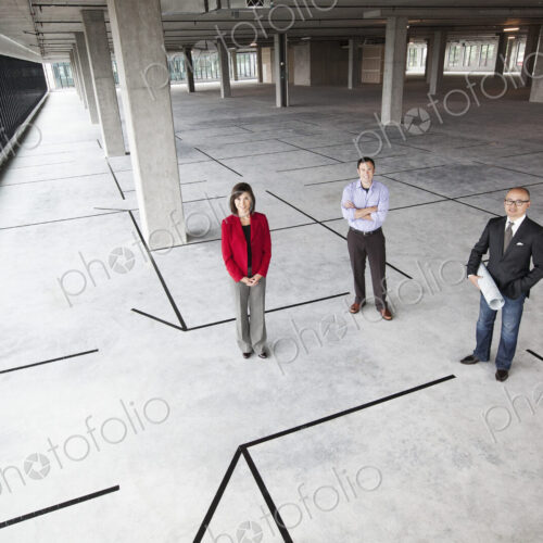 Asian architect with caucasian man and woman business people in a new raw business space.