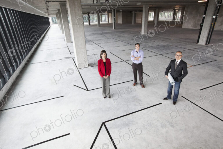 Asian architect with caucasian man and woman business people in a new raw business space.