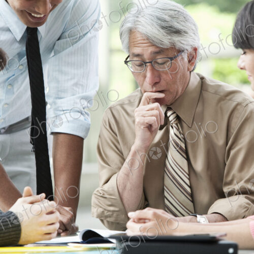 Asian businessman in a meeting with three other mixed race business team members. Asian businessman in a meeting with three other mixed race business team members.