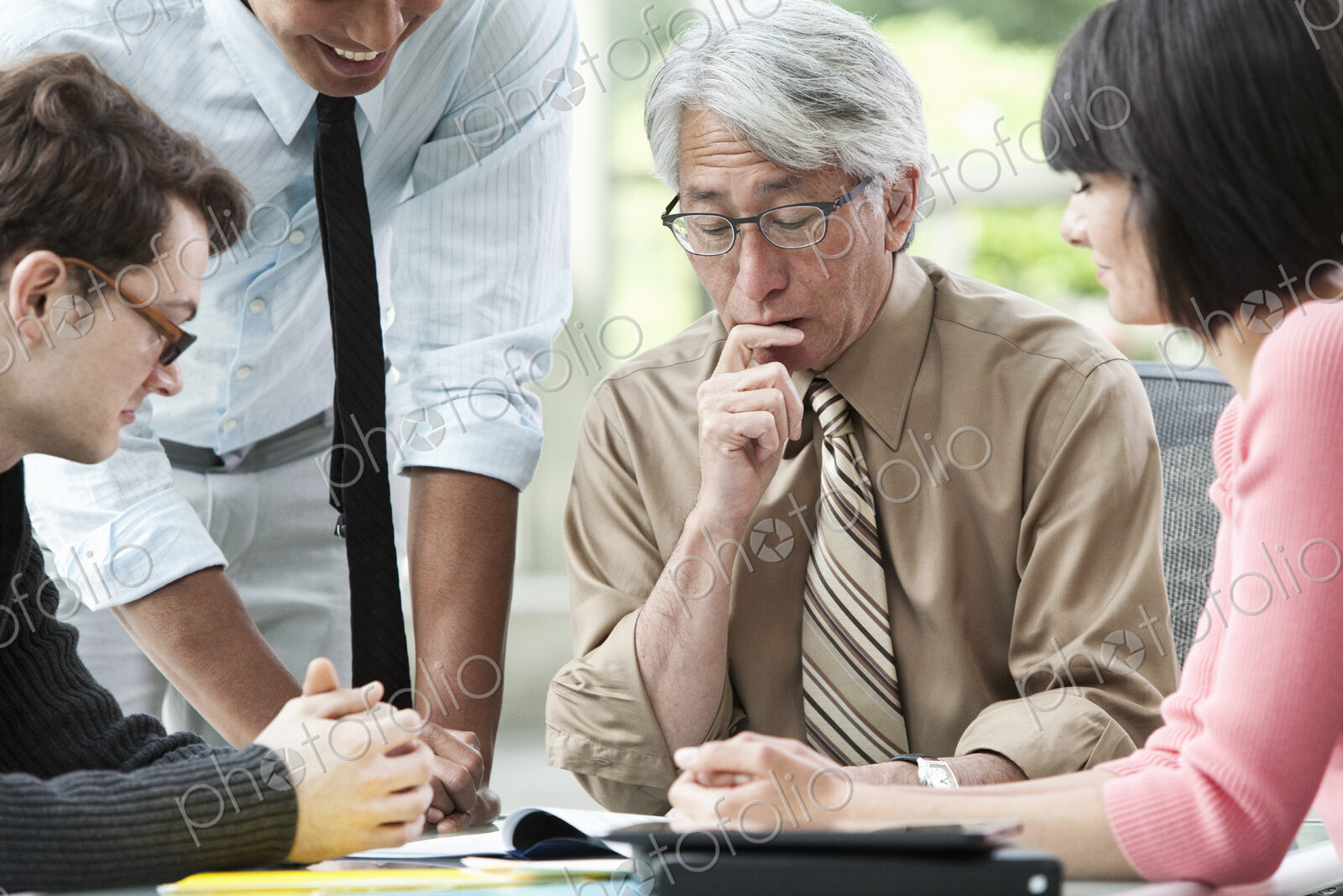Asian businessman in a meeting with three other mixed race business team members.
