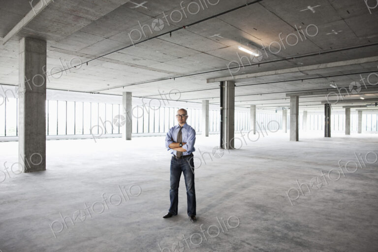 Asian businessman in a new empty raw office space.