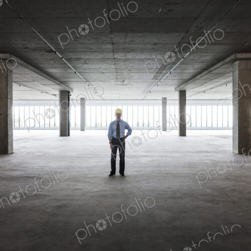 Asian businessman in a new empty raw office space.