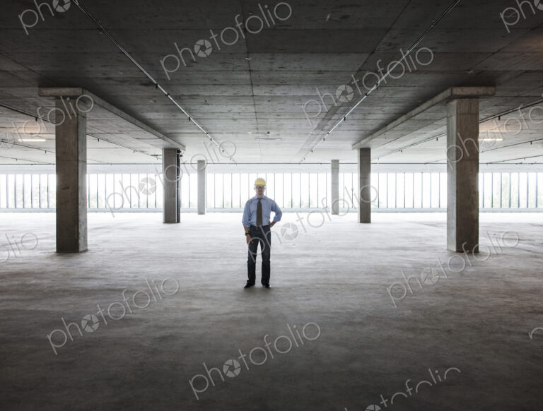 Asian businessman in a new empty raw office space.