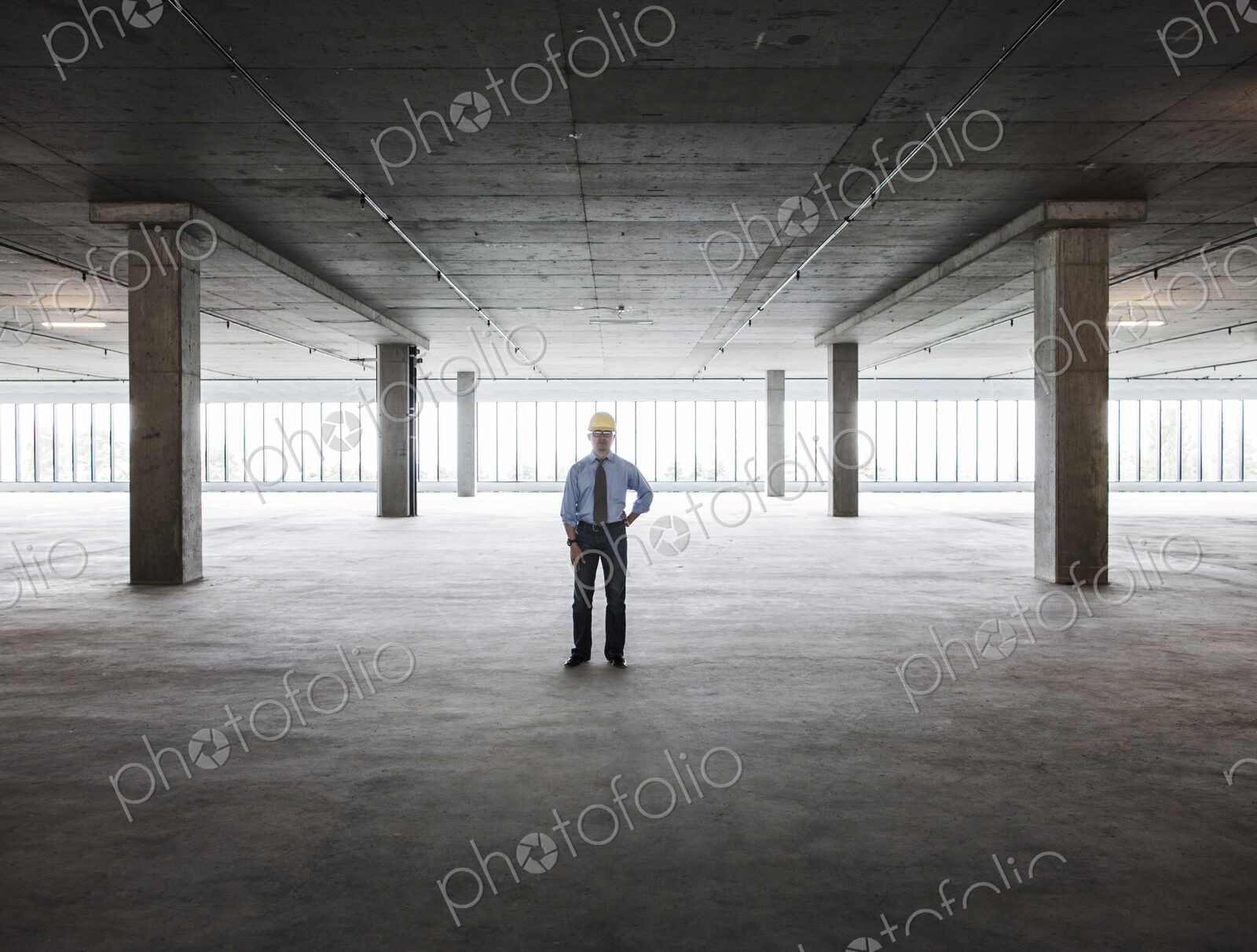 Asian businessman in a new empty raw office space.