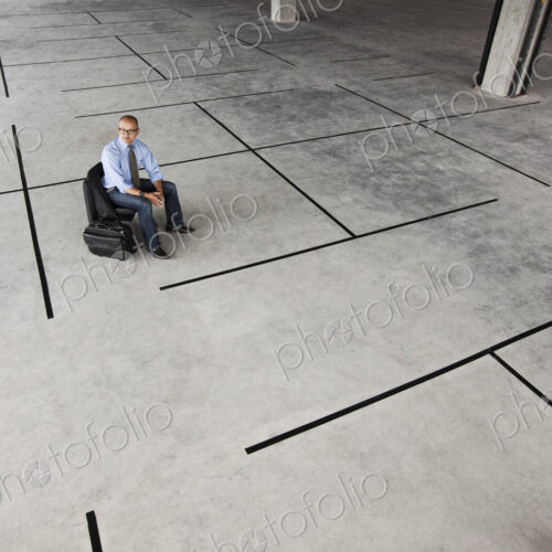Asian businessman taking a look at a large empty raw office space.