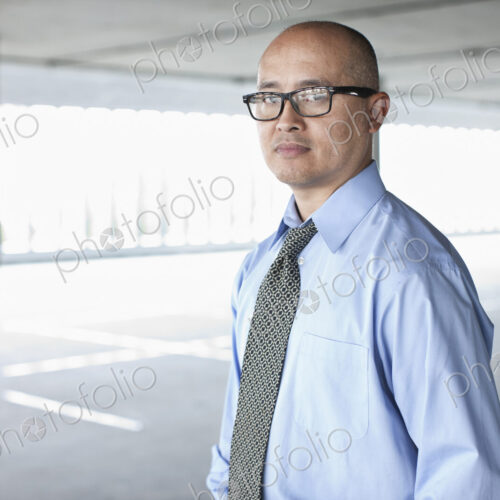 Asian businessman taking a look at a large empty raw office space.