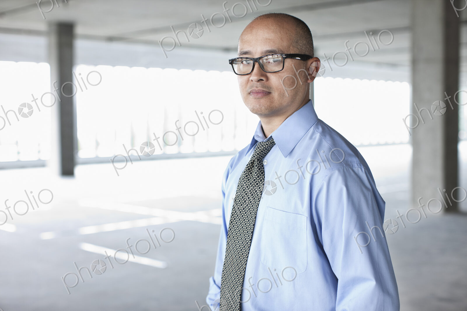 Asian businessman taking a look at a large empty raw office space.
