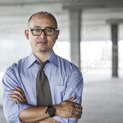 Asian businessman taking a look at a large empty raw office space.