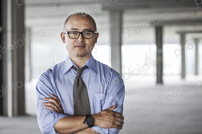 Asian businessman taking a look at a large empty raw office space.