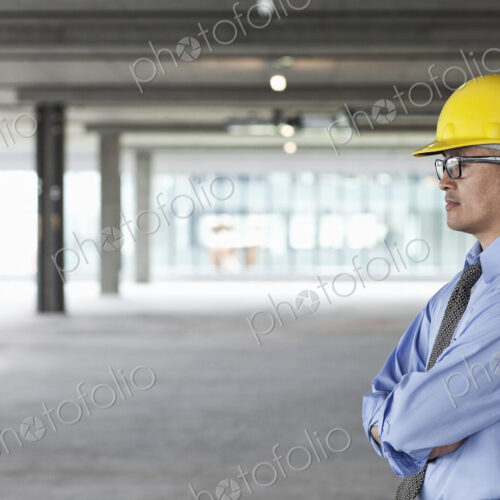 Asian businessman taking a look at a large empty raw office space. Asian businessman taking a look at a large empty raw office space.