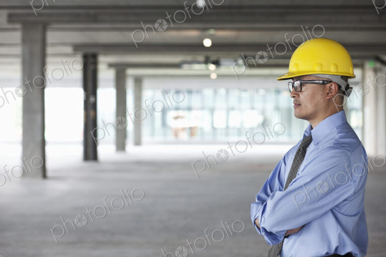 Asian businessman taking a look at a large empty raw office space.