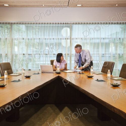Asian businesswoman and caucasian businessman meeting in a conference room