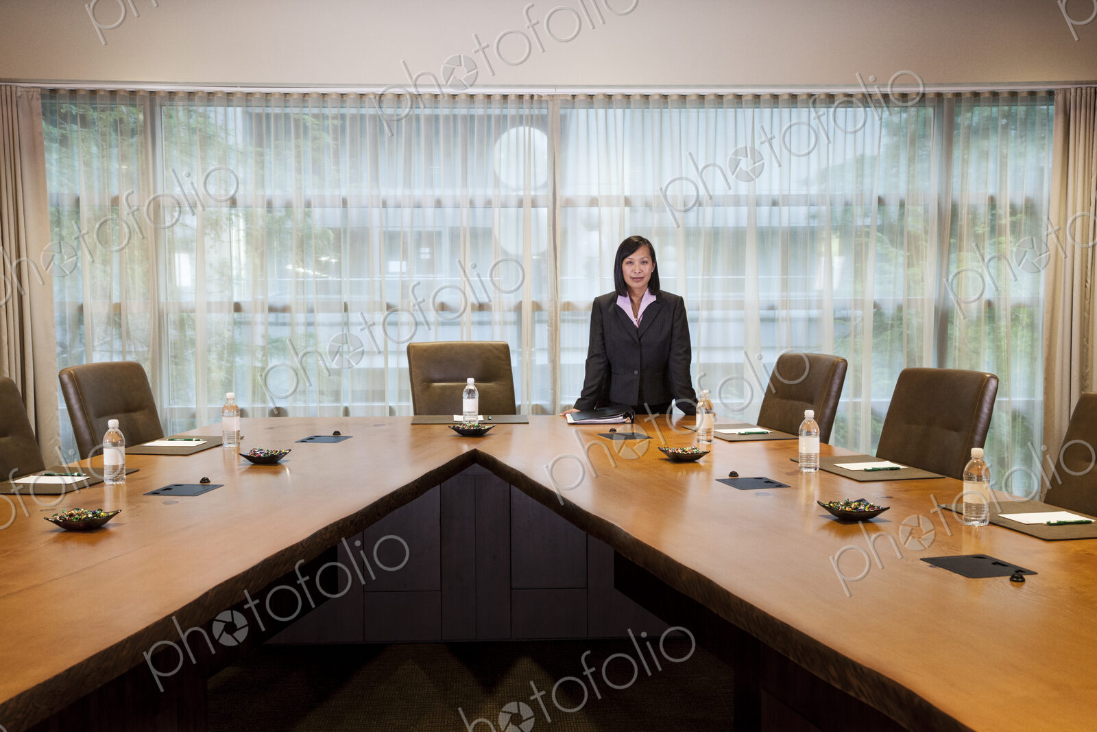 Asian businesswoman at the head of a conference room table.
