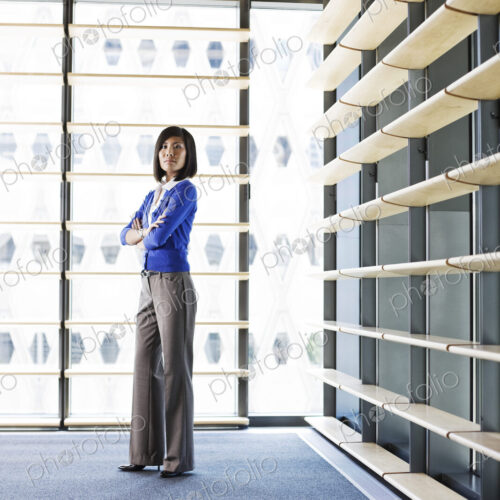 Asian businesswoman in the lobby of a large office building.
