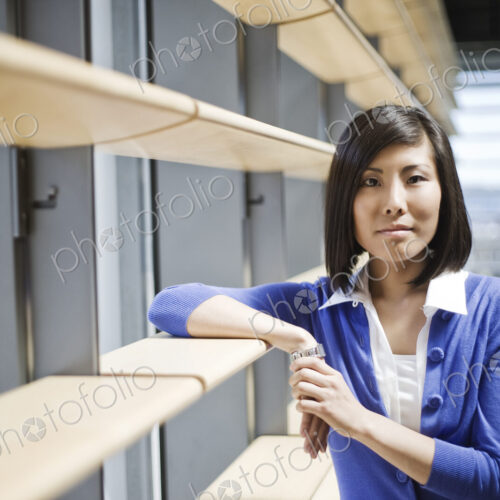 Asian businesswoman in the lobby of a large office building. Asian businesswoman in the lobby of a large office building.