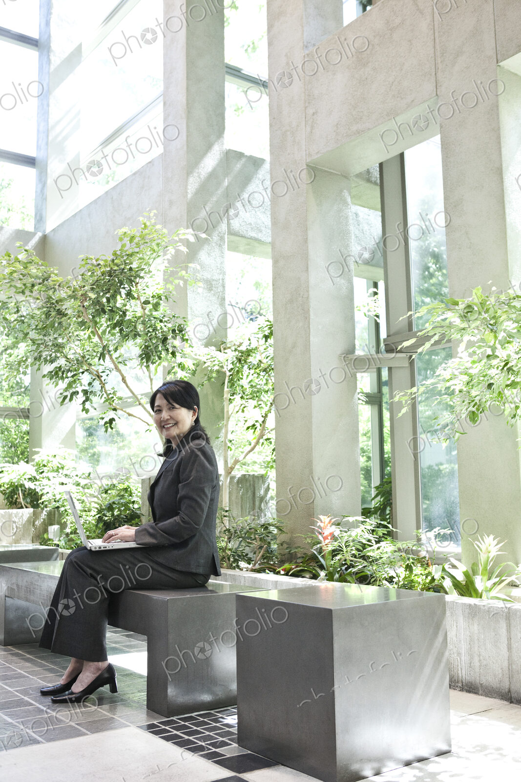 Asian businesswoman working in a large open lobby area.