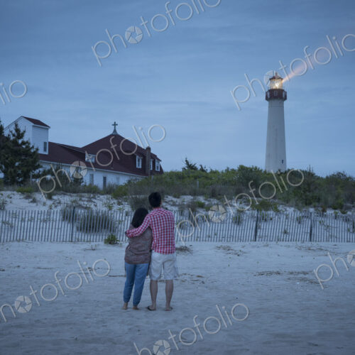 Asian couple watching lighthouse at beach Asian couple watching lighthouse at beach