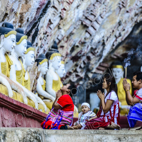 Asian family praying at Buddha temple Asian family praying at Buddha temple