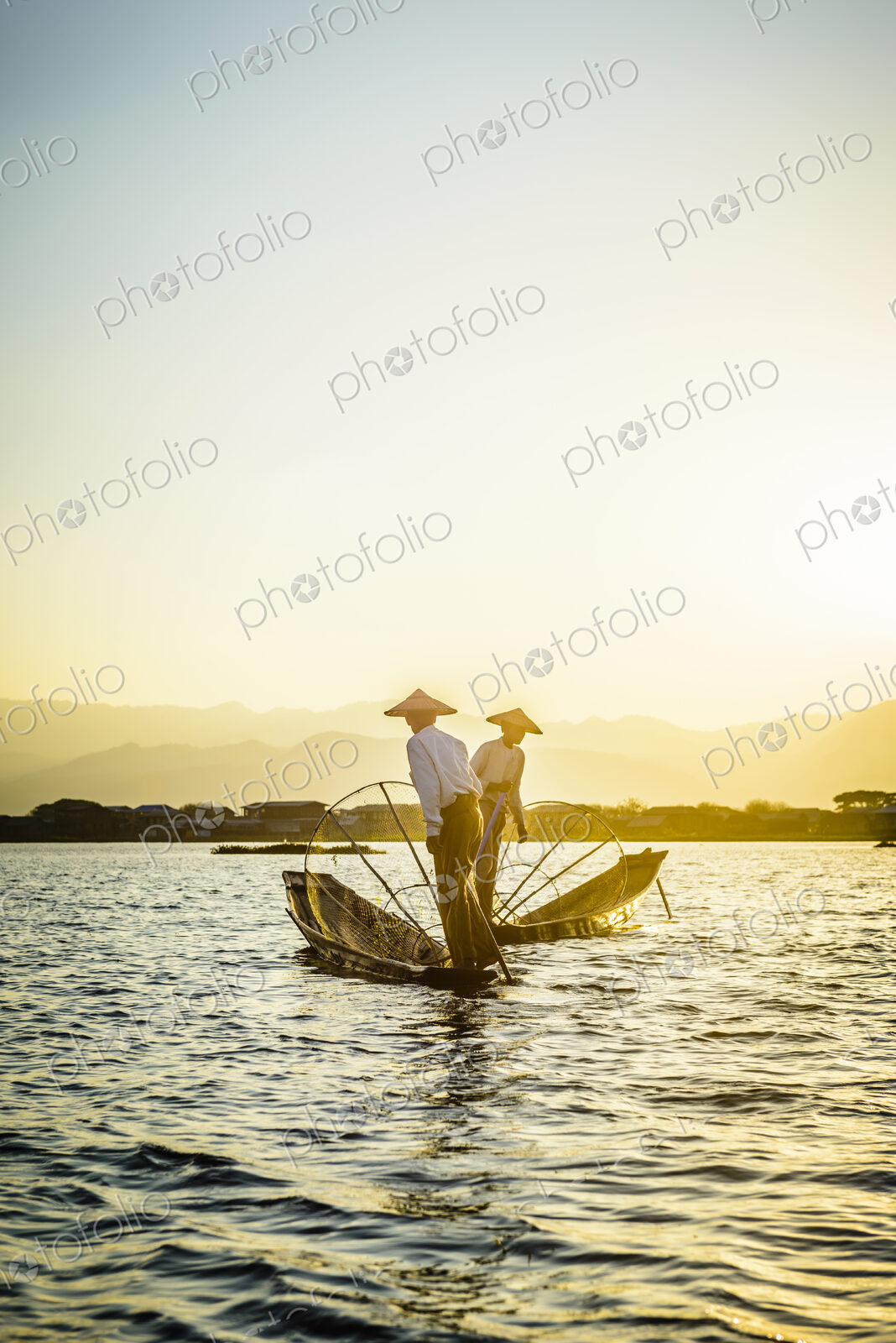 Asian fishermen fishing in canoes on river