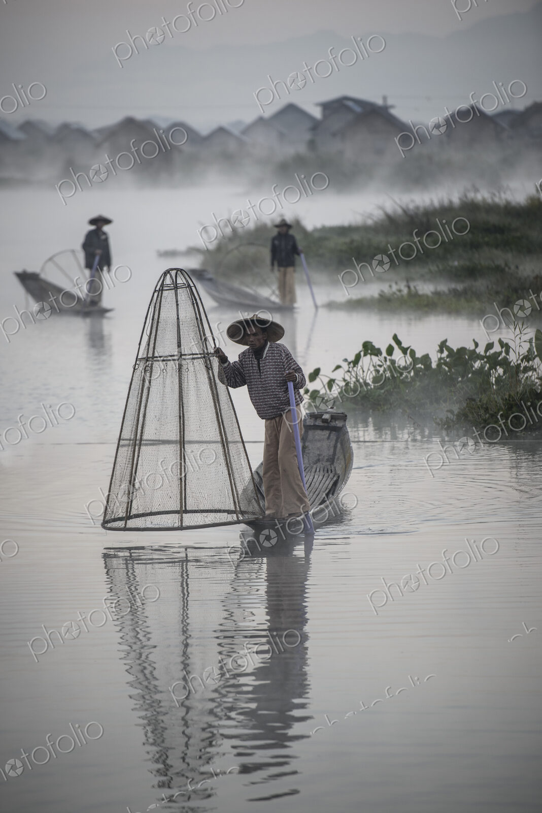 Asian fishermen fishing in canoes on river